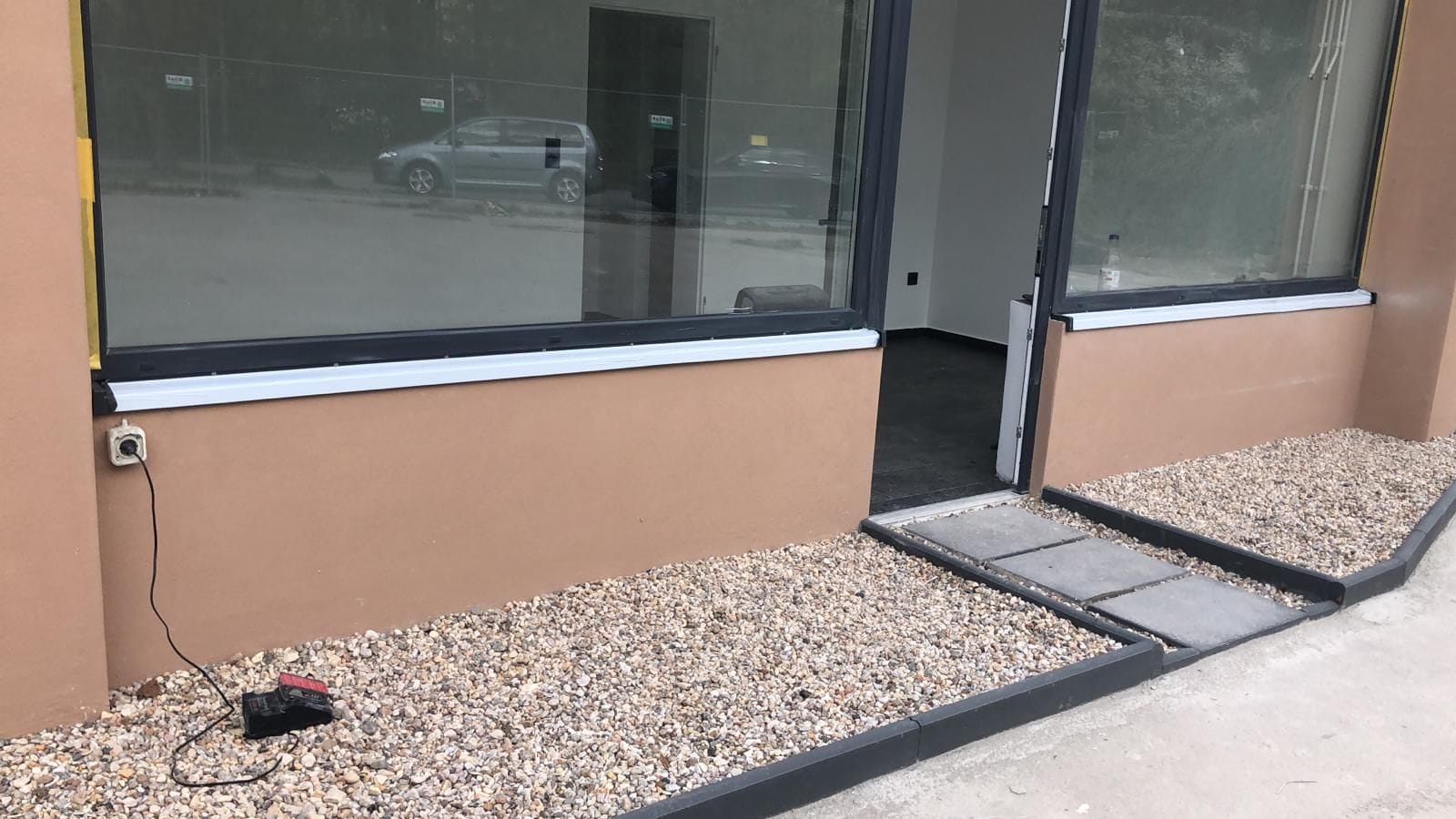 Neue Fensterfront mit Kiesstreifen vor der Fassade