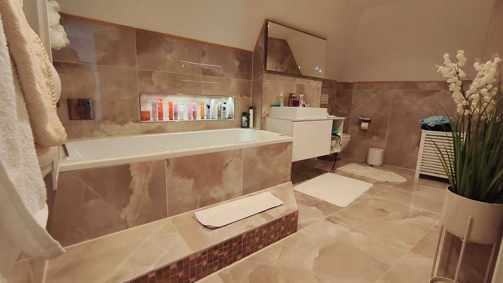 Fertiges Bad mit Badewanne und großformatigen Fliesen