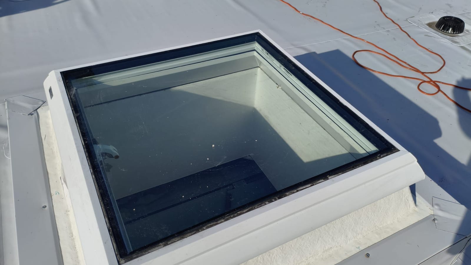 Neues Flachdachfenster in der weißen Dachabdichtung